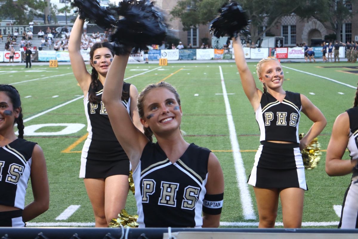 Katherine Touger, 12, waves to the crowd during the varsity football game against Robinson on Sept. 6. Touger was named captain of the cheer team for the 2024-2025 season.