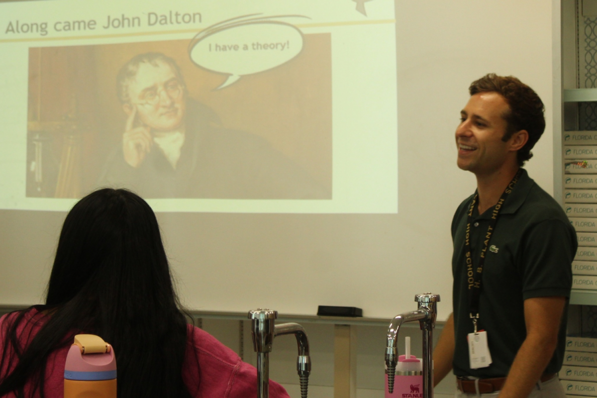 Taylor Zeisloft teaches his fourth period chemistry class as he laughs at a student’s joke. Read more to learn about how Zeisloft became a teacher.