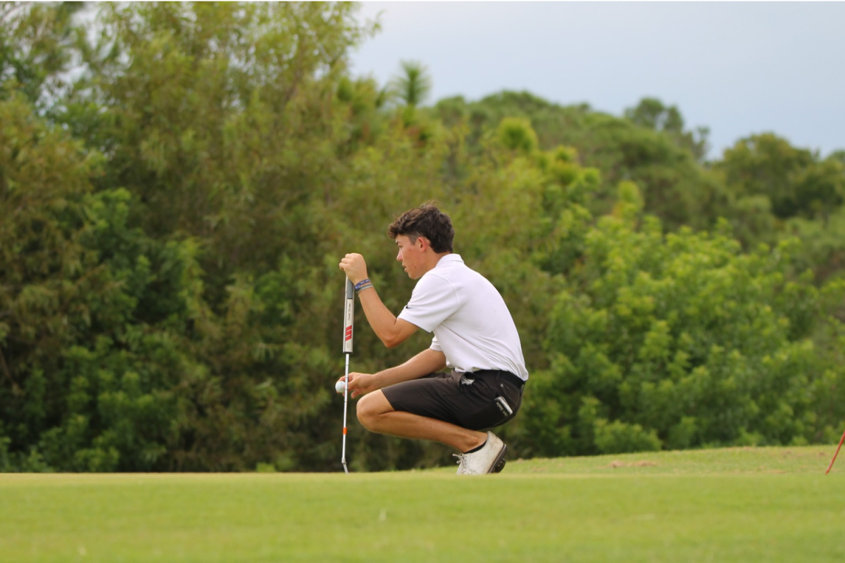 Grant Goslin, 12, uses an iron to hit the golf ball out of the fairway. Goslin played the number two seed at the Thursday, Sept. 12 match.