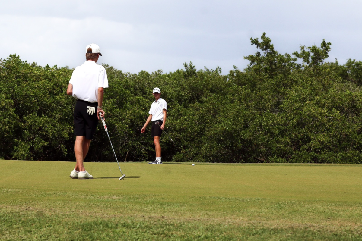 Tyler Lessinger, 11, and Wyatt LaGasse, 9, watch as the golf ball moves closer to the hole after a putt. LaGasse started his first year on the team this season.