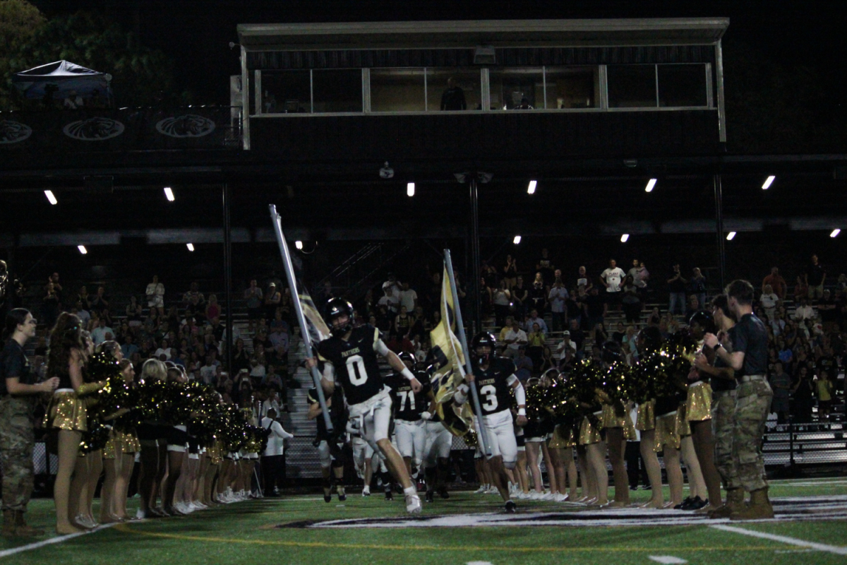 Max Hunt and Cristian Peirats, both seniors, run out with the Plant High School football flags on Friday, Nov. 1, for Senior Night. The varsity team won the game.
