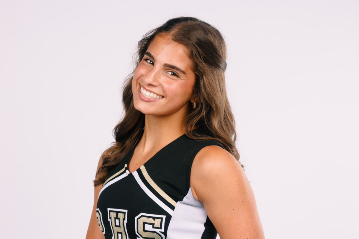 Skylar Mayer, a senior, smiles for the camera in her cheerleading uniform. Mayer was made captain this year.