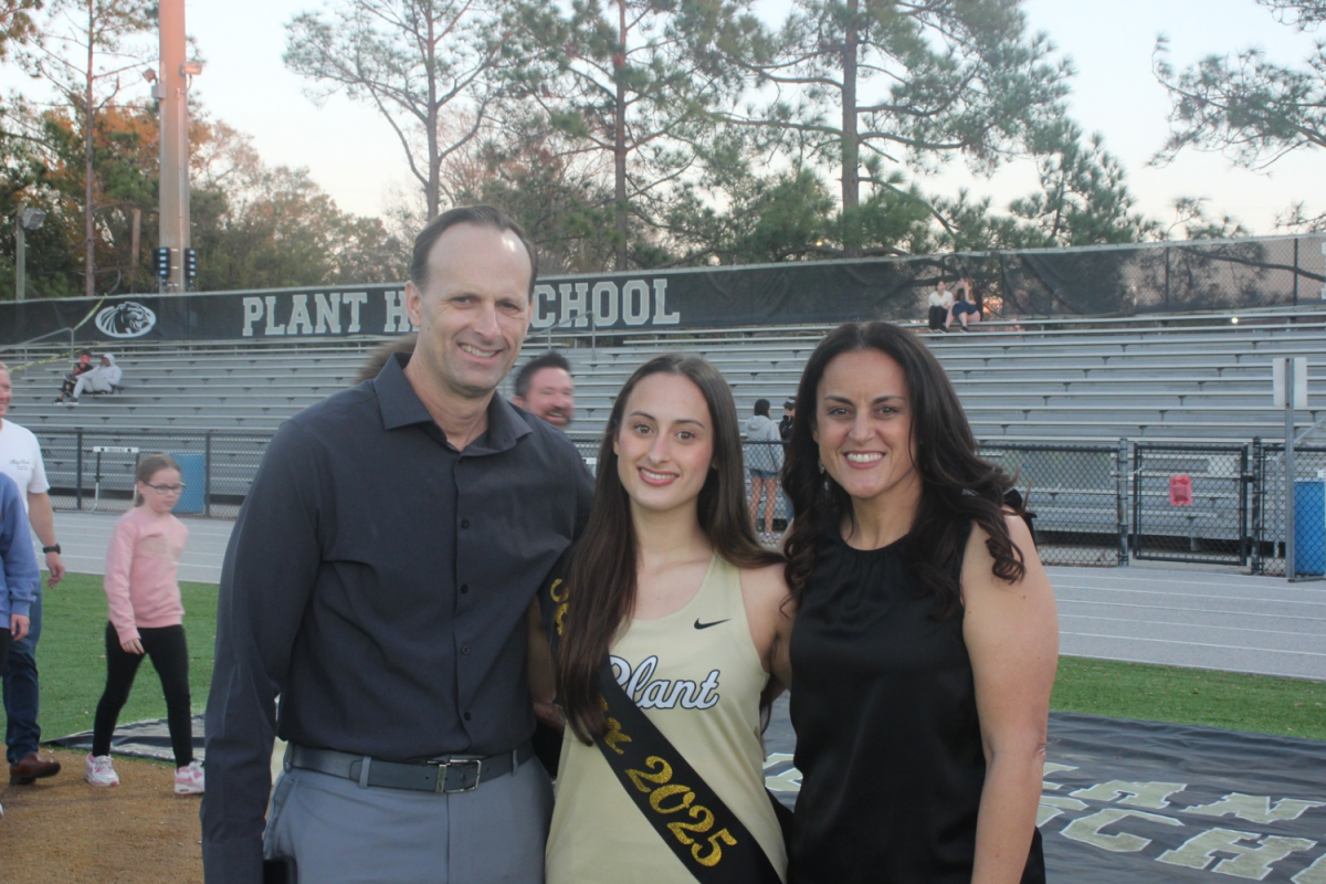 Sophia Dicus (12) poses with her parents after walking down the track for Senior night. The 2025 season will have concluded Dicus’s Track and Field career at Plant come May.