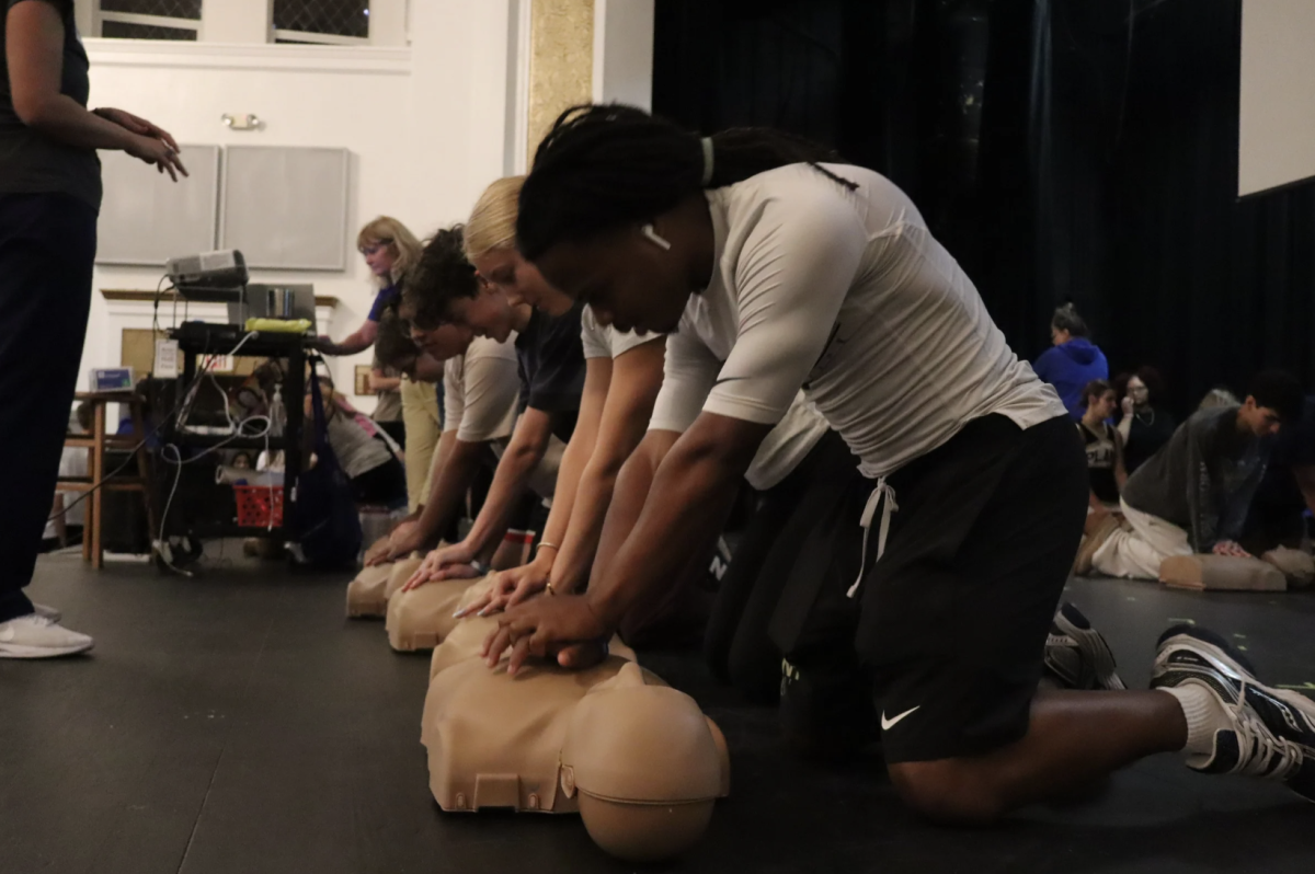  M'kai Silas, 11, performs chest compressions on the manikin. Silas and the rest of the students followed the medical staff’s instructions during the compressions.  