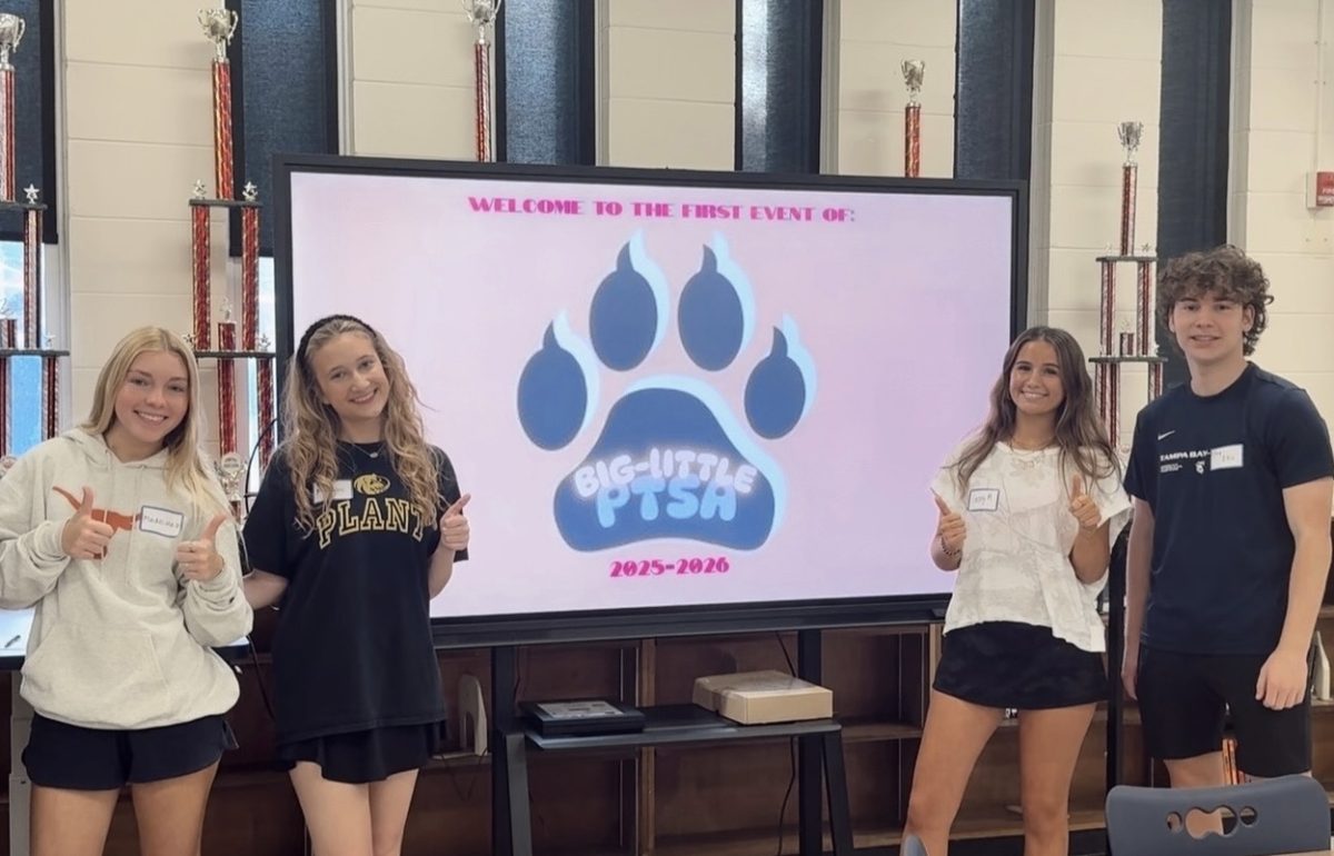  Madeline Davidson (12), Madden Moore (11), Georgi McGonnigal (12) and Trey Ellis (12) stand in the library for the first event of the Bigs/Littles program. The program broke a school record of club attendance with over 200 participants. 