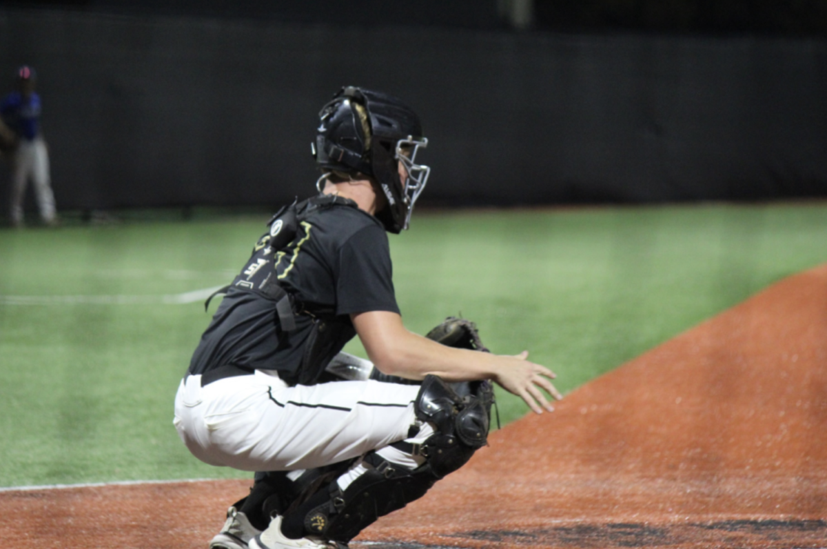 Jordan Olivia (11) prepares to catch the ball while practicing with the pitcher. Olivia committed to the University of Florida for his position as a catcher.
