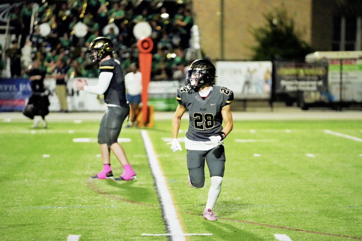 Running back Nick Girsch (12) sprints down the field at the sound of the ball snapping to quarterback Tripp Brown (12). Girsch scored a touchdown, securing the Panthers with 28 points to finish the game. 