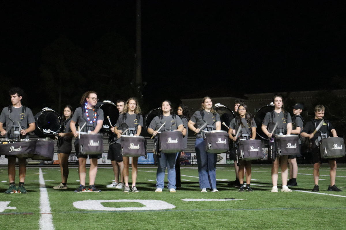Members of the marching band smile while gazing up into the stands. Since they won the competition, they performed at Plant High School sporting events. 