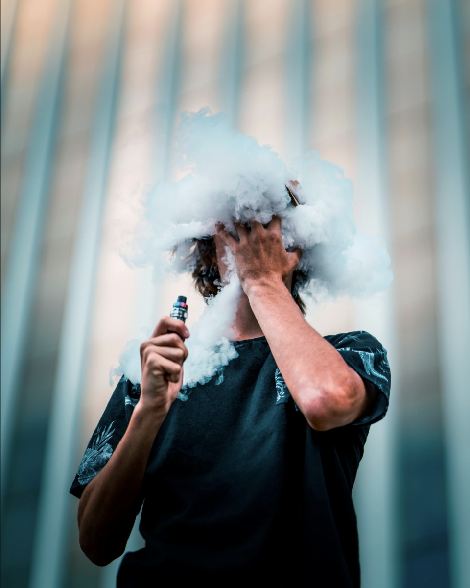 A cloud of vapor fills a teenager’s face. The rise of nicotine use began spreading years ago, impacting schools.