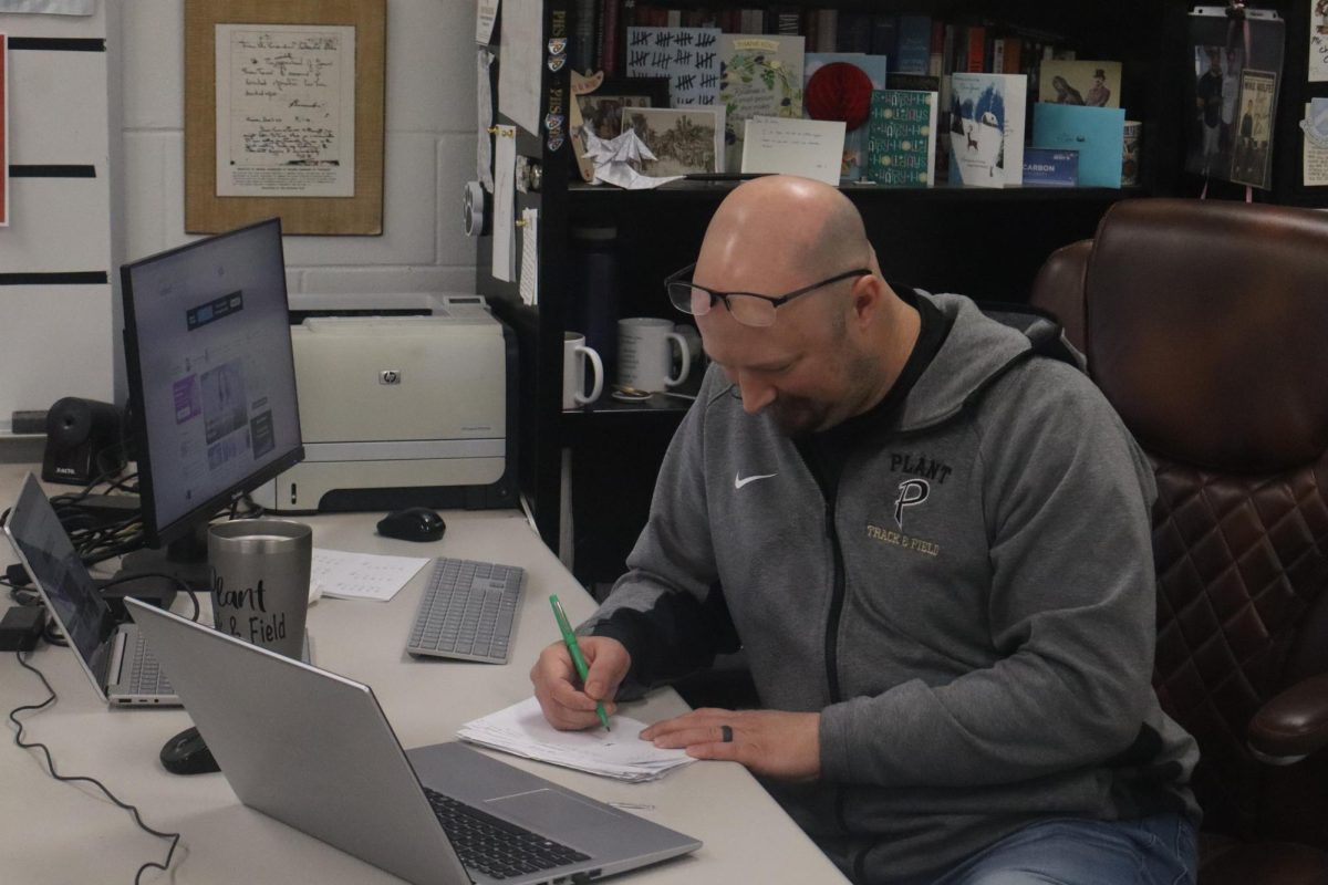 Christopher Carbon carefully grades his most recent round of AP U.S. history quizzes. Carbon gives daily quizzes to his AP U.S. history classes to make sure students are correctly understanding the content they learned the previous day. 