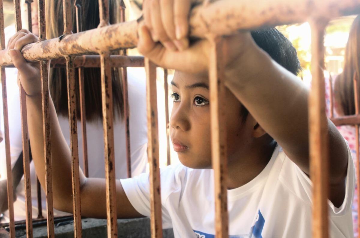A child grips rusted bars, looking out for the longing of freedom. This captured the representation of humans mentally and socially being stuck in cages.