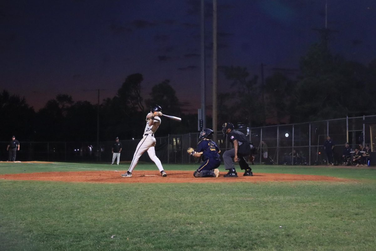 Will Meade (12) swings and lands his ball in the outfield, securing a run to first base. Meade concluded his time with the team at home after four years with the Panthers.