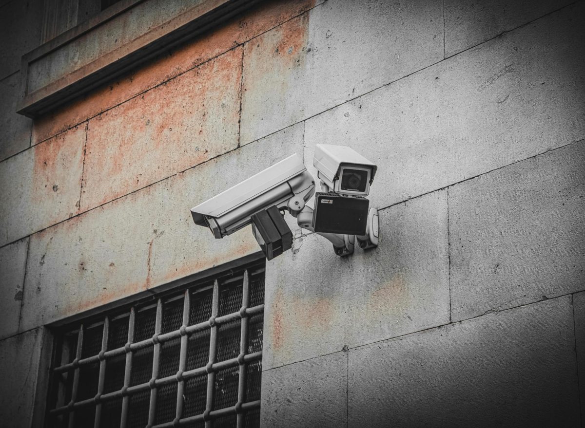 Cameras monitor the back alley of an office building. Cameras can be used for both practical safety and for surveilling those who want privacy in a malicious manner.